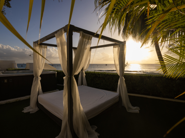 Barbados luxury modern beachfront villa beach bed at sunset with Caribbean Sea view beyond