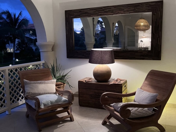 Balcony at twilight with soft lighting and comfy chairs at stylish apartment in Sugar Hill, Barbados.