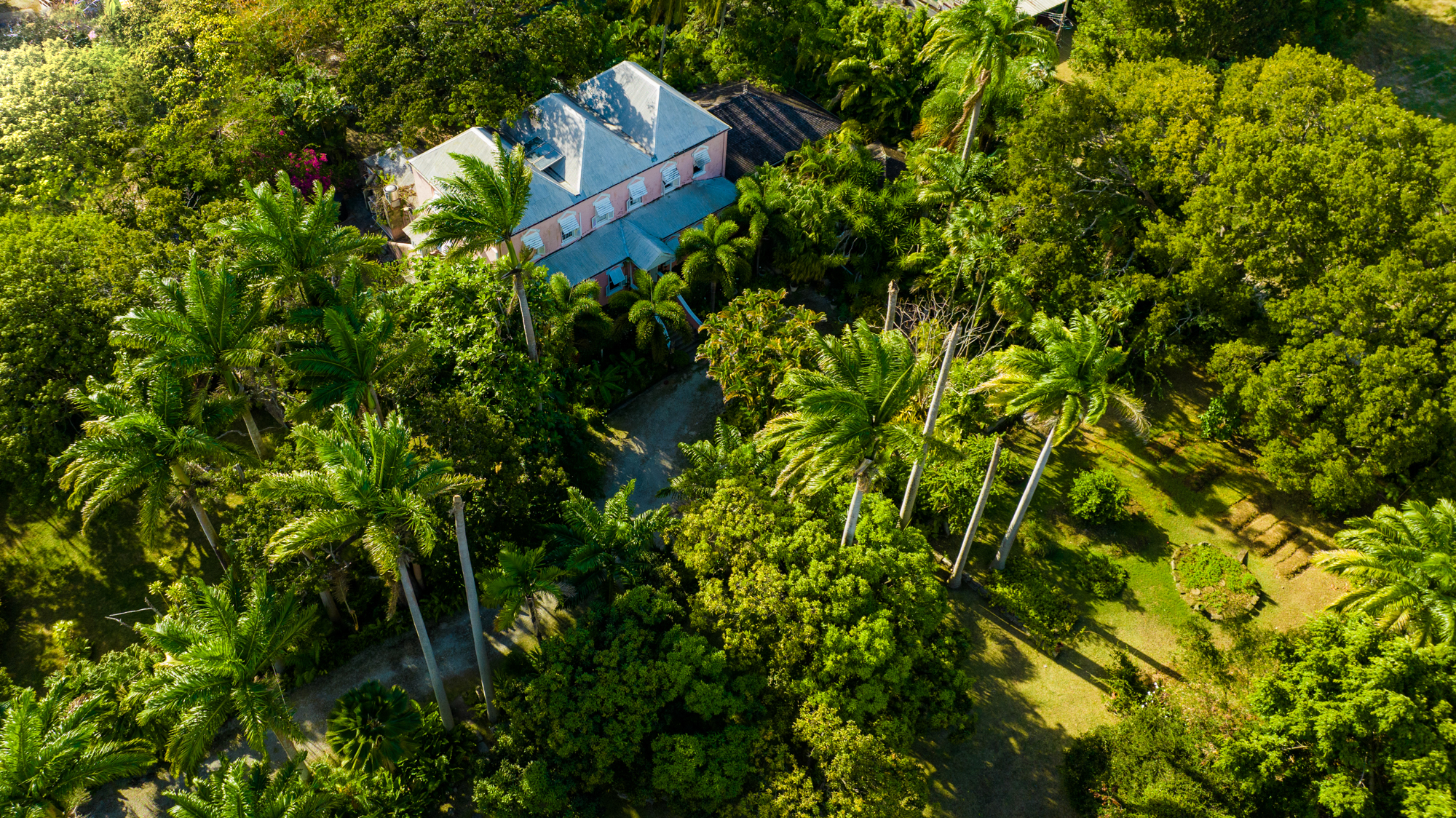 Lancaster Great House aerial view presenting Plantation House surrounded by green lush tropical gardens