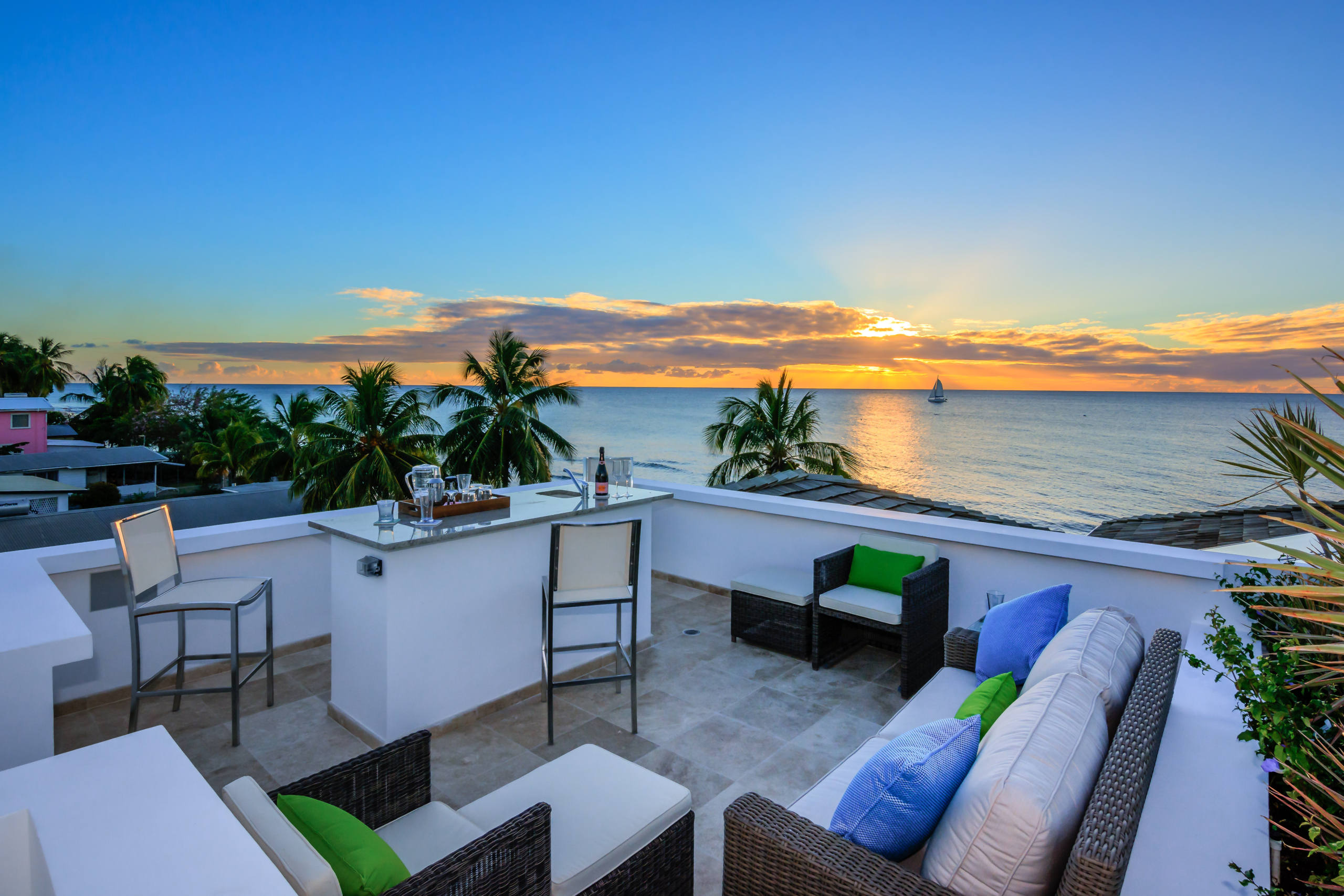 Beautiful Caribbean homes spotlight property Nirvana, the view to the ocean at sunset with white furniture