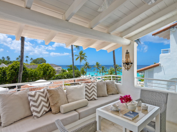 Terrace with neutral soft furnishings and blue sky at beachfront condo property Glitter Bay 304