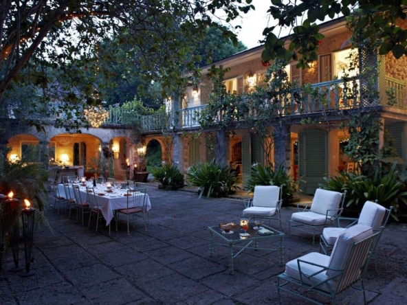 Outdoor patio with lighting at dusk at Oliver Messel house, Fustic House in Barbados