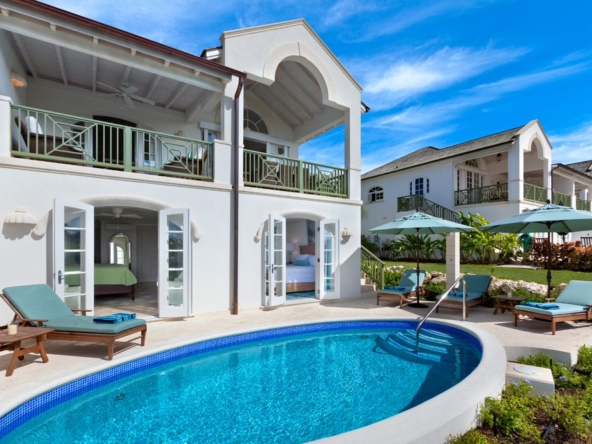 Exterior view of white villa, swimming pool, adn blue sky at Royal Westmoreland Townhouse