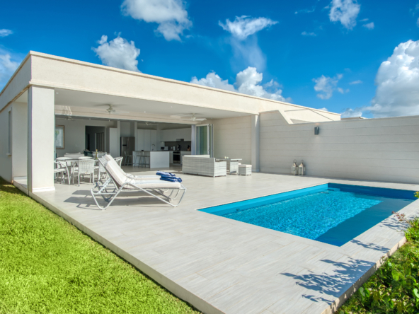 Exterior view of three bedroom villa, swimming pool, and blue sky at Westmoreland Hills 12.