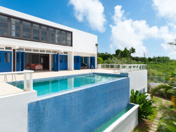 Exterior view of St Peter House, a luxury five-bedroom villa with a stunning pool deck, mature gardens, and panoramic ocean views.