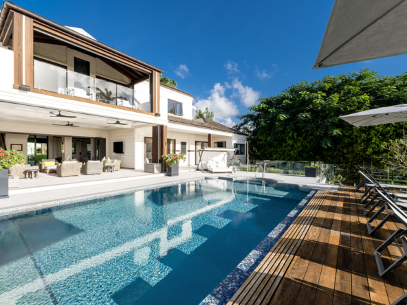 Exterior view of white villa, swimming pool, and blue sky at Royal Westmoreland Townhouse - flamboyant drive 3