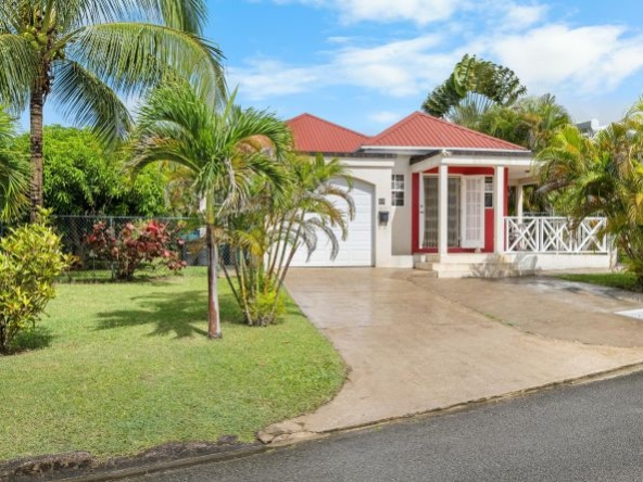 An exterior view of a charming 3-bedroom home in Bakers Woods, St. Peter, showcasing its well-maintained facade, lush green gardens, and a peaceful residential setting near Barbados' stunning West Coast.