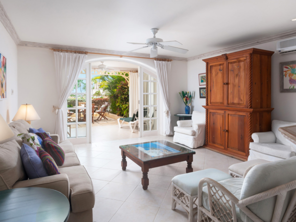 An image showing the living room in the peaceful one bedroom apartment at Port St Charles, which showcases elegant furnishings, a comfortable seating area, and large windows with serene lagoon views.