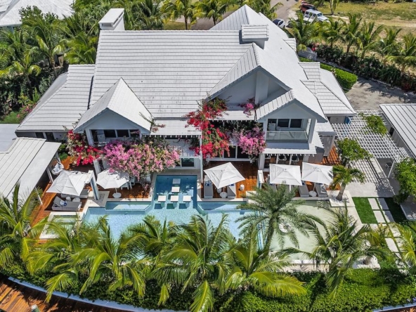 Luxurious waterfront estate for sale featuring 7 bedrooms, private dock, heated pool, and guest house in a gated Caribbean community.
