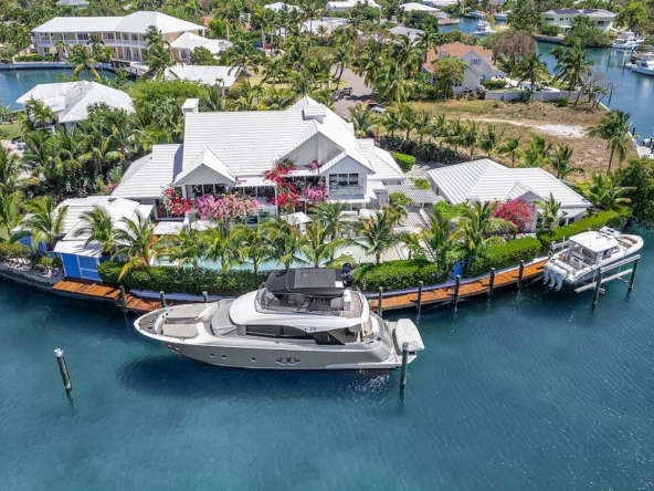 Luxurious waterfront estate for sale featuring 7 bedrooms, private dock, heated pool, and guest house in a gated Caribbean community.